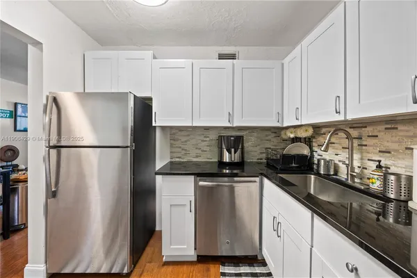 a kitchen with stainless steel appliances granite countertop a refrigerator sink and cabinets