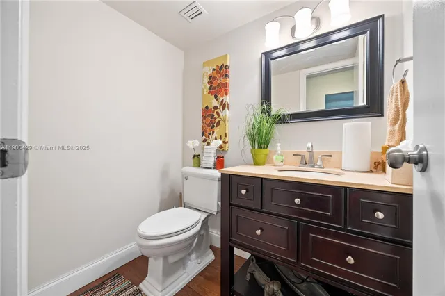 a bathroom with a toilet a sink and mirror