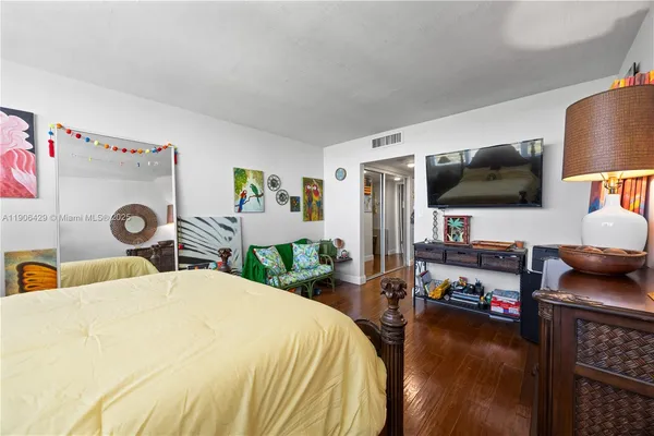 a bedroom with a bed and a flat screen tv