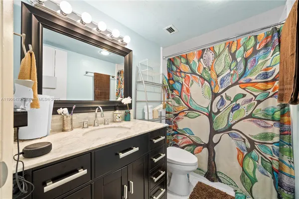 a bathroom with a sink a toilet and a mirror