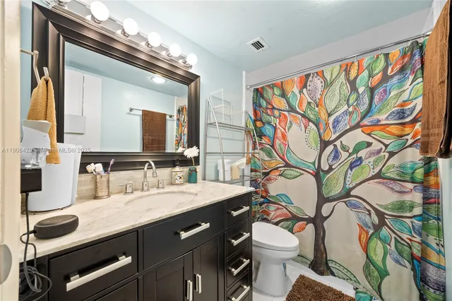 a bathroom with a sink a toilet and a mirror