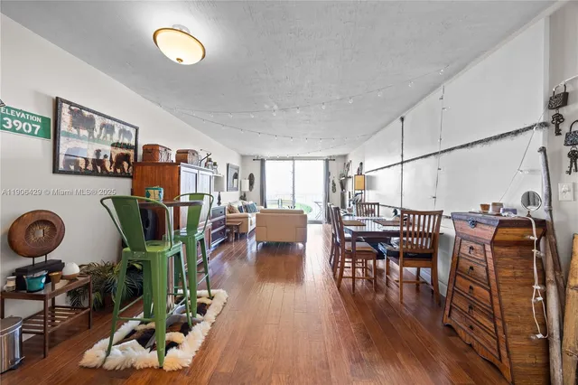 a dining room with furniture kitchen view and wooden floor
