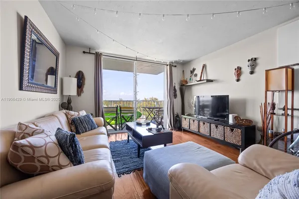 a living room with furniture a flat screen tv and a large window