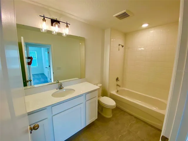 view of a hallway with wooden floor and a bathroom