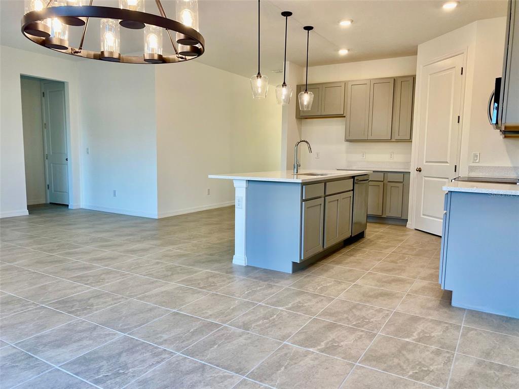 2190 Derwent Drive Davenport, FL 33896 - Photo 26 of 30 a open kitchen with kitchen island granite countertop a sink and a stove