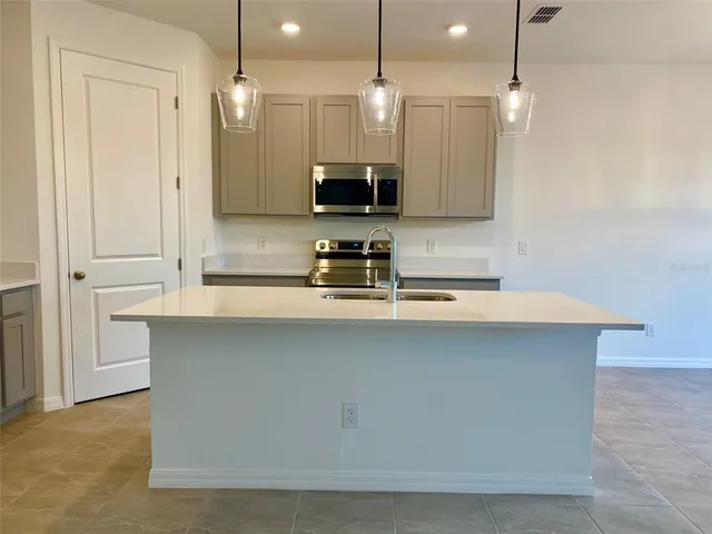 a kitchen with a sink a counter space and cabinets