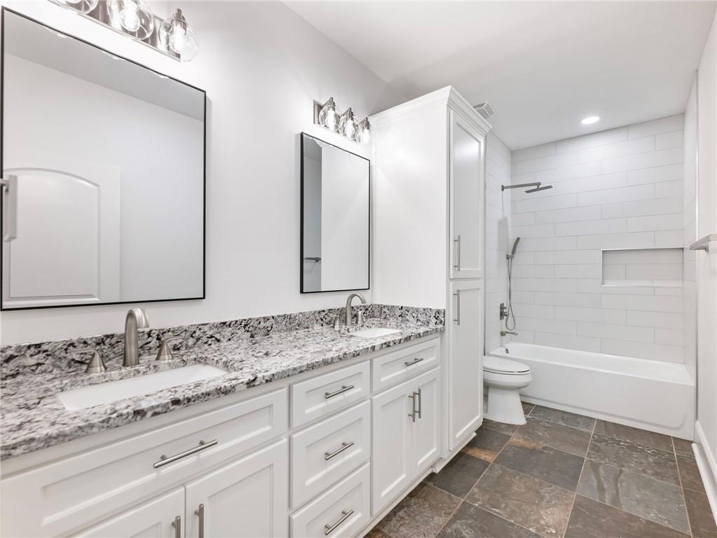 5651 Old Wilkie Road Gainesville, GA 30506 - Photo 60 of 78 a bathroom with a granite countertop sink double mirror bathtub and next to a window