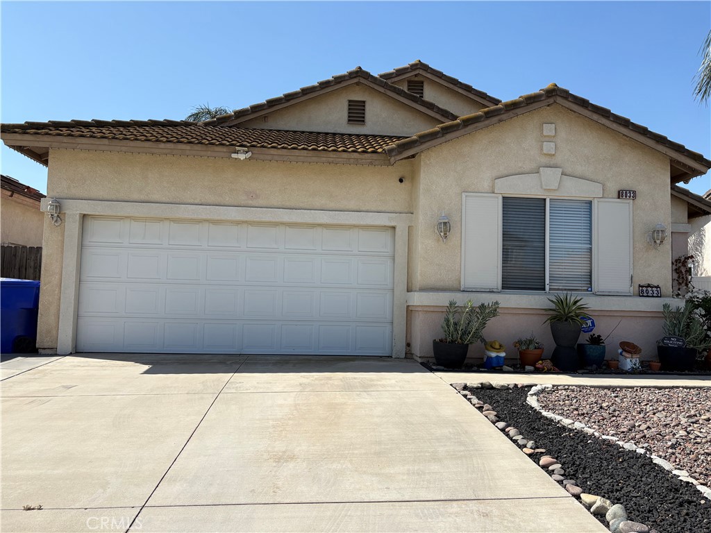 8033 David Way Riverside, CA 92509 - Photo 2 of 23 a front view of a house with a yard