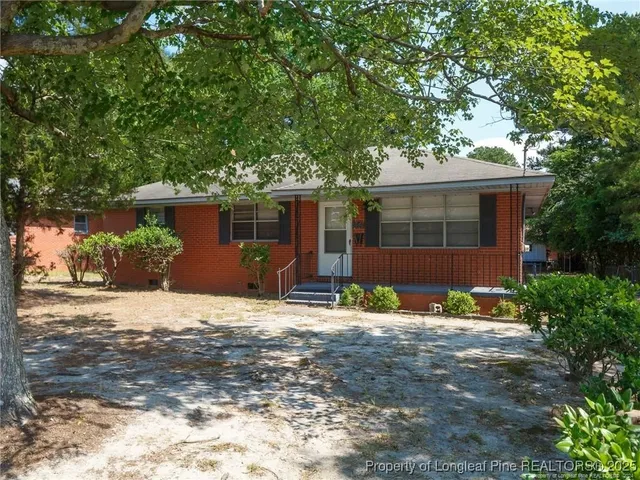 a front view of a house with a yard and potted plants