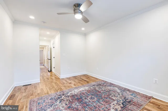 a view of a big room with wooden floor and a ceiling fan