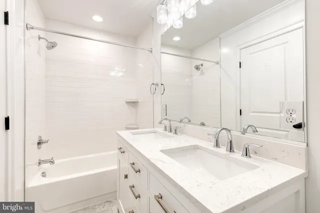 a bathroom with a bathtub double vanity sink and mirror