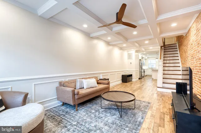 a living room with furniture a rug and white walls