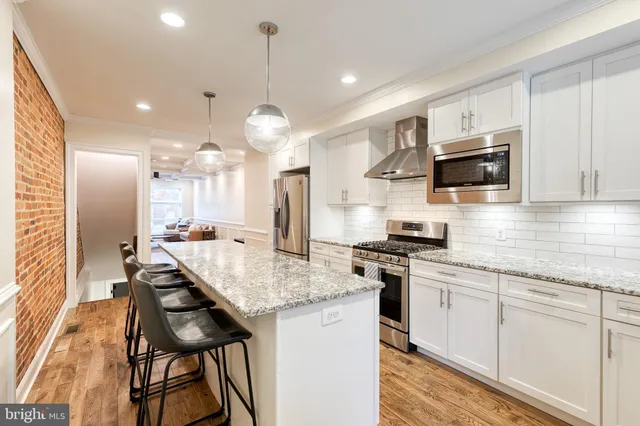 a kitchen with stainless steel appliances kitchen island granite countertop a stove a sink and a microwave