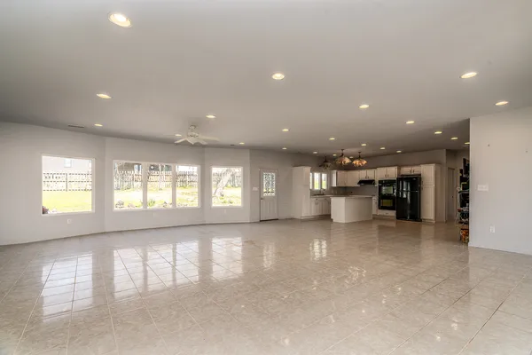 a view of empty room with a kitchen and window