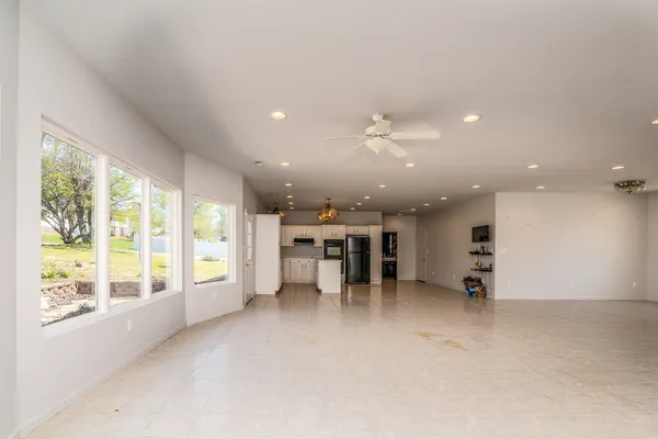 an empty room with furniture and large windows