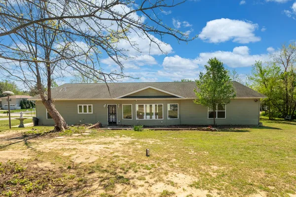 a front view of house with yard and trees around