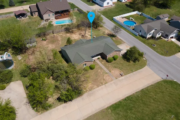 an aerial view of a house with a yard and lake