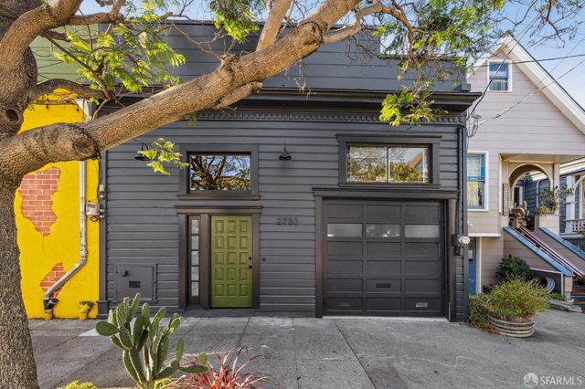a view of a brick house with potted plants