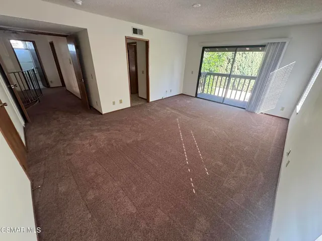 an empty room with windows and closet