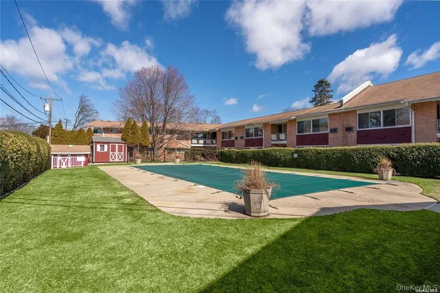 a view of yard with swimming pool and trees in the background