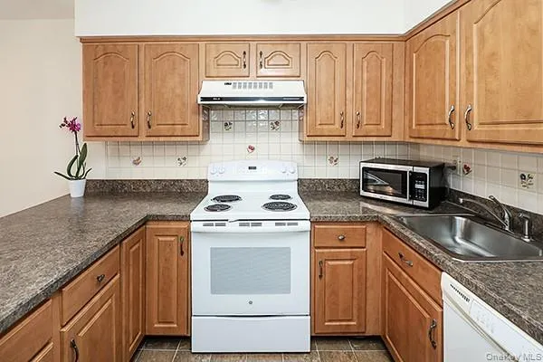 a kitchen with granite countertop a sink stove and cabinets