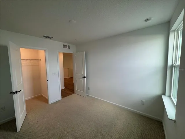 an empty room with closet and a fireplace