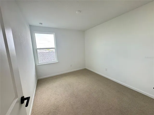 an empty room with mirror and a sink