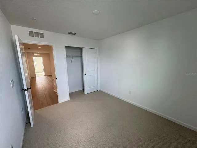 an empty room with windows and closet