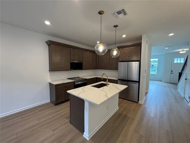 a kitchen with stainless steel appliances a stove top oven and refrigerator