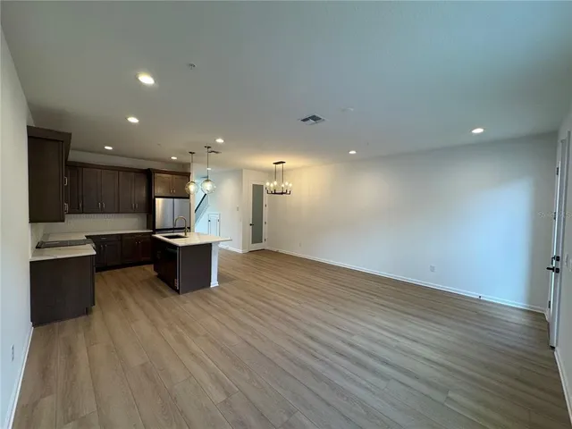 a open kitchen with a sink dishwasher a stove and a refrigerator with wooden floor