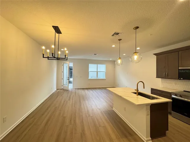 a view of a kitchen stove a sink and wooden floor