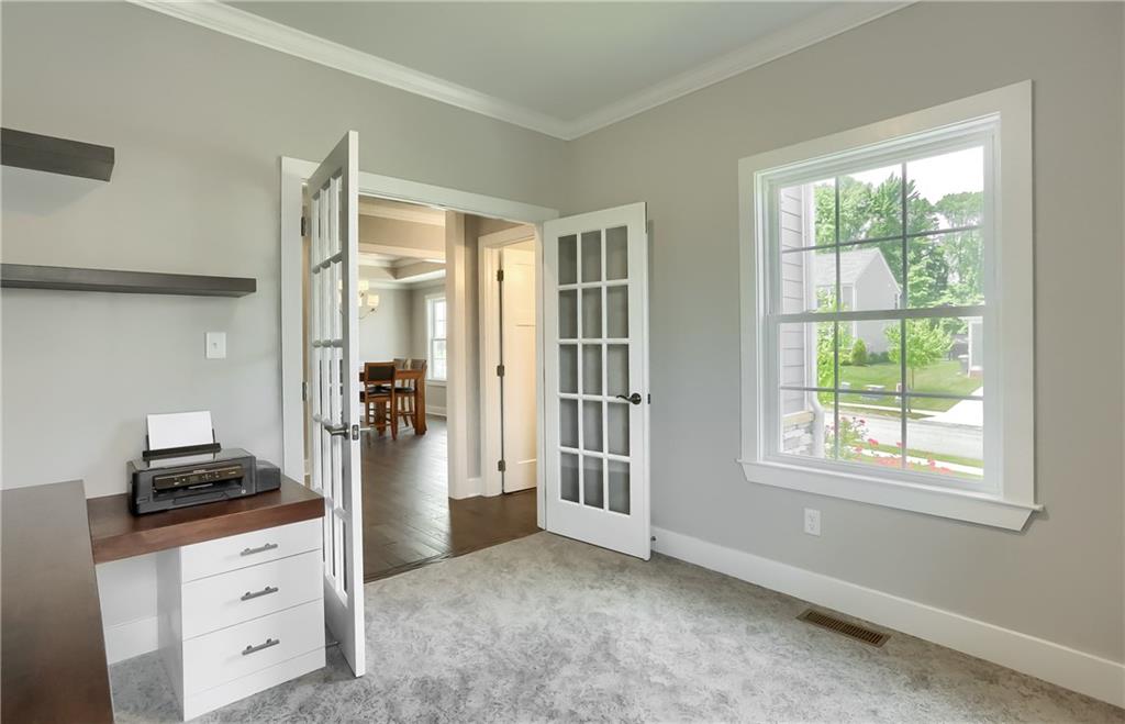 Notice bright windows, neutral tones, and plush carpeting.