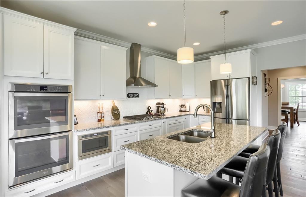 Granite counter tops are complimented with a custom backsplash and, a plethora of modern white cabinetry. 