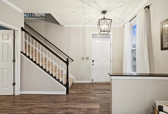 a bedroom with a bed chandelier and a window