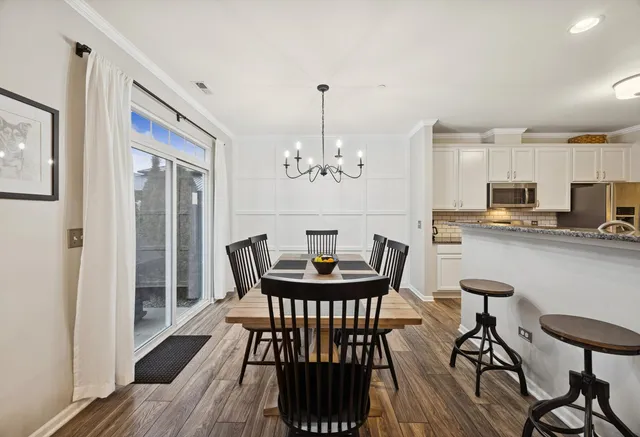 a kitchen with stainless steel appliances granite countertop a stove top oven a sink dishwasher and a refrigerator with wooden floor