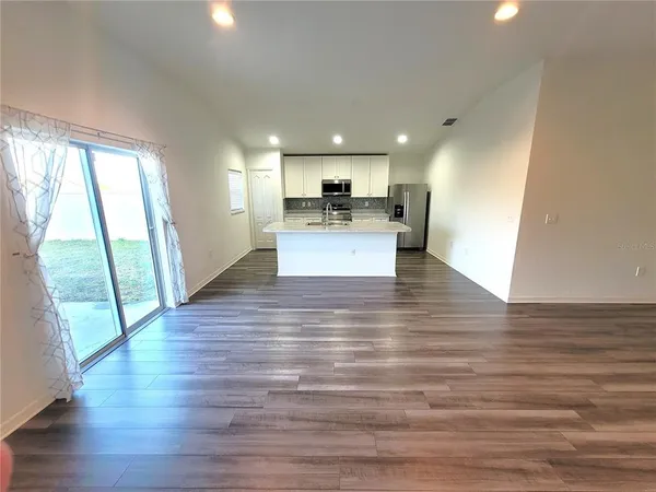 a view of a living room with wooden floor and a large window