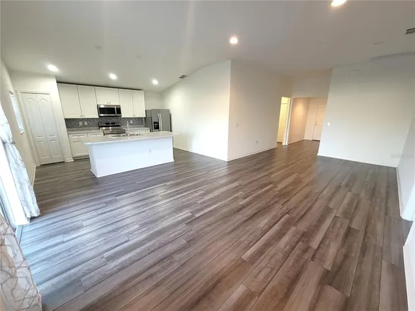 a view of kitchen with cabinets potted plant and wooden floor