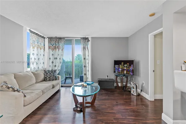 a living room with furniture a wooden floor and a painting on the wall