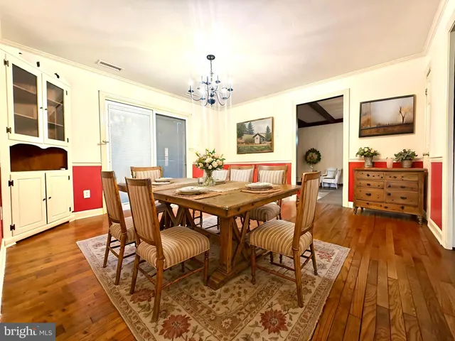 an empty room with wooden floor and chandelier