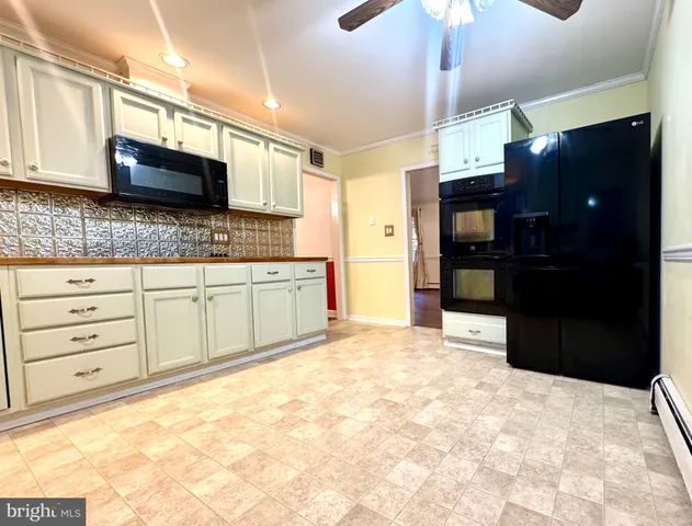 a kitchen with stainless steel appliances kitchen island granite countertop a refrigerator and a sink