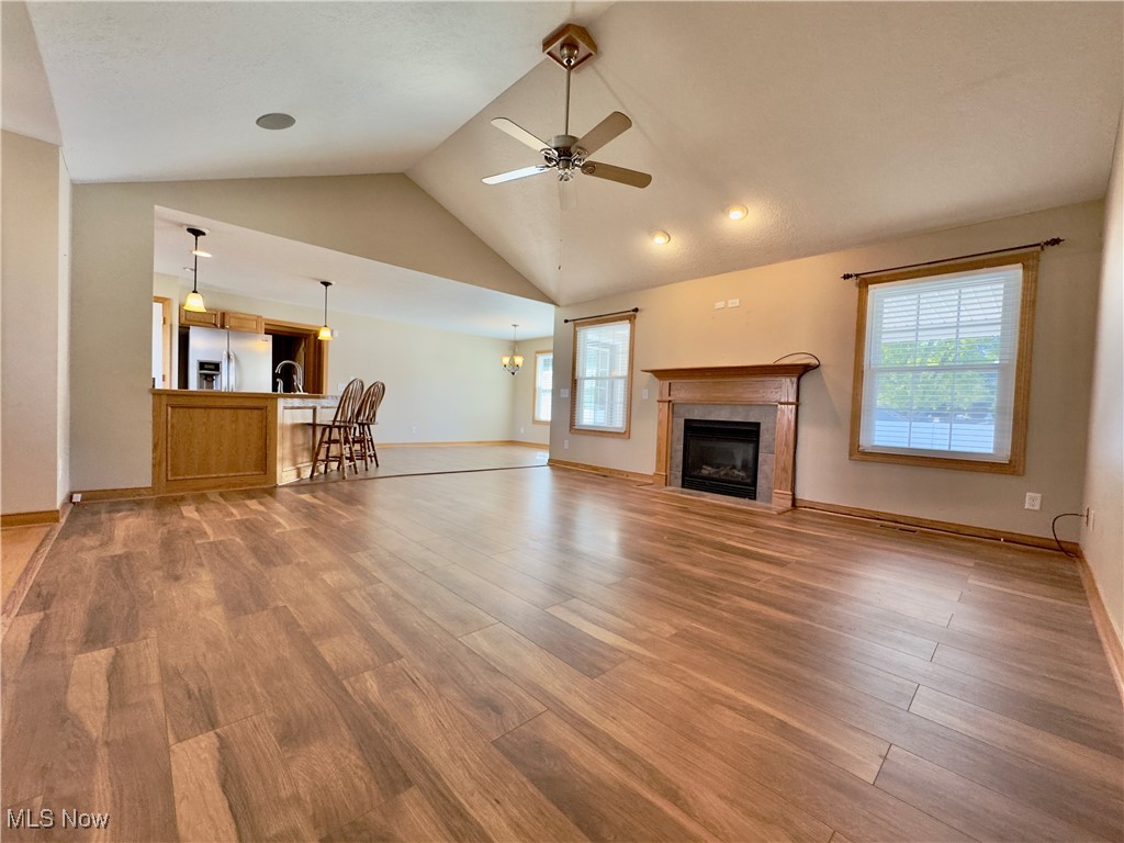 6014 Wentworth Road Southwest Canton, OH 44706 - Photo 4 of 22 Unfurnished living room featuring a gas fireplace, high vaulted ceiling, LVT floors, ceiling fan, and recessed lighting