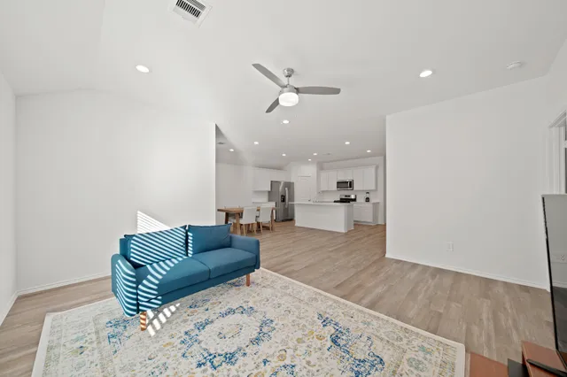 a living room with furniture and a wooden floor