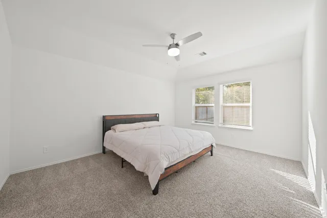 a bed sitting in a bedroom next to a window