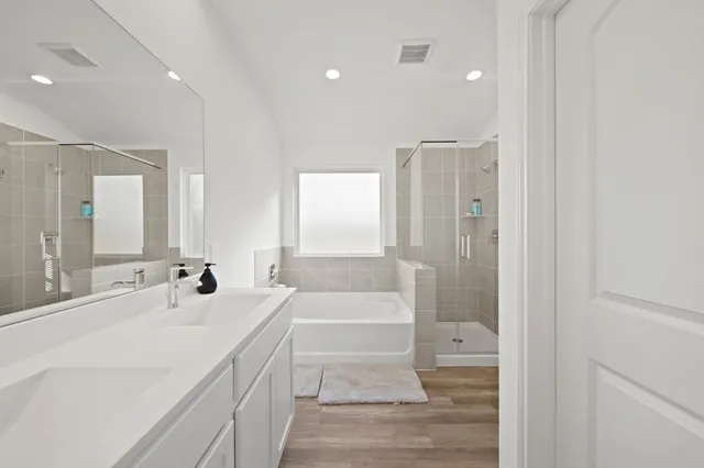 a bathroom with a double vanity sink a mirror and a shower