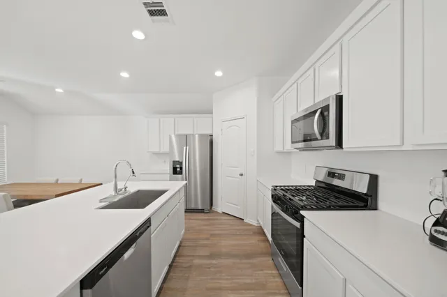 a kitchen with stainless steel appliances granite countertop a sink stove and refrigerator