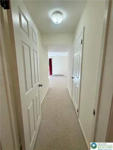 a view of a hallway to a livingroom with stairs