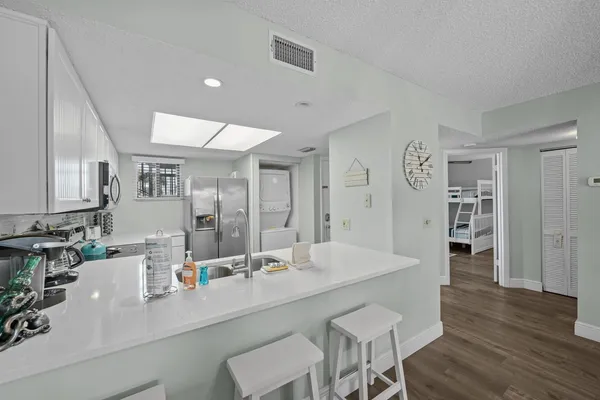 a view of kitchen island a sink and wooden floor