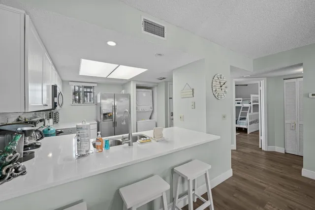 a view of kitchen island a sink and wooden floor