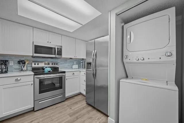 a kitchen with a stove a washer and a refrigerator