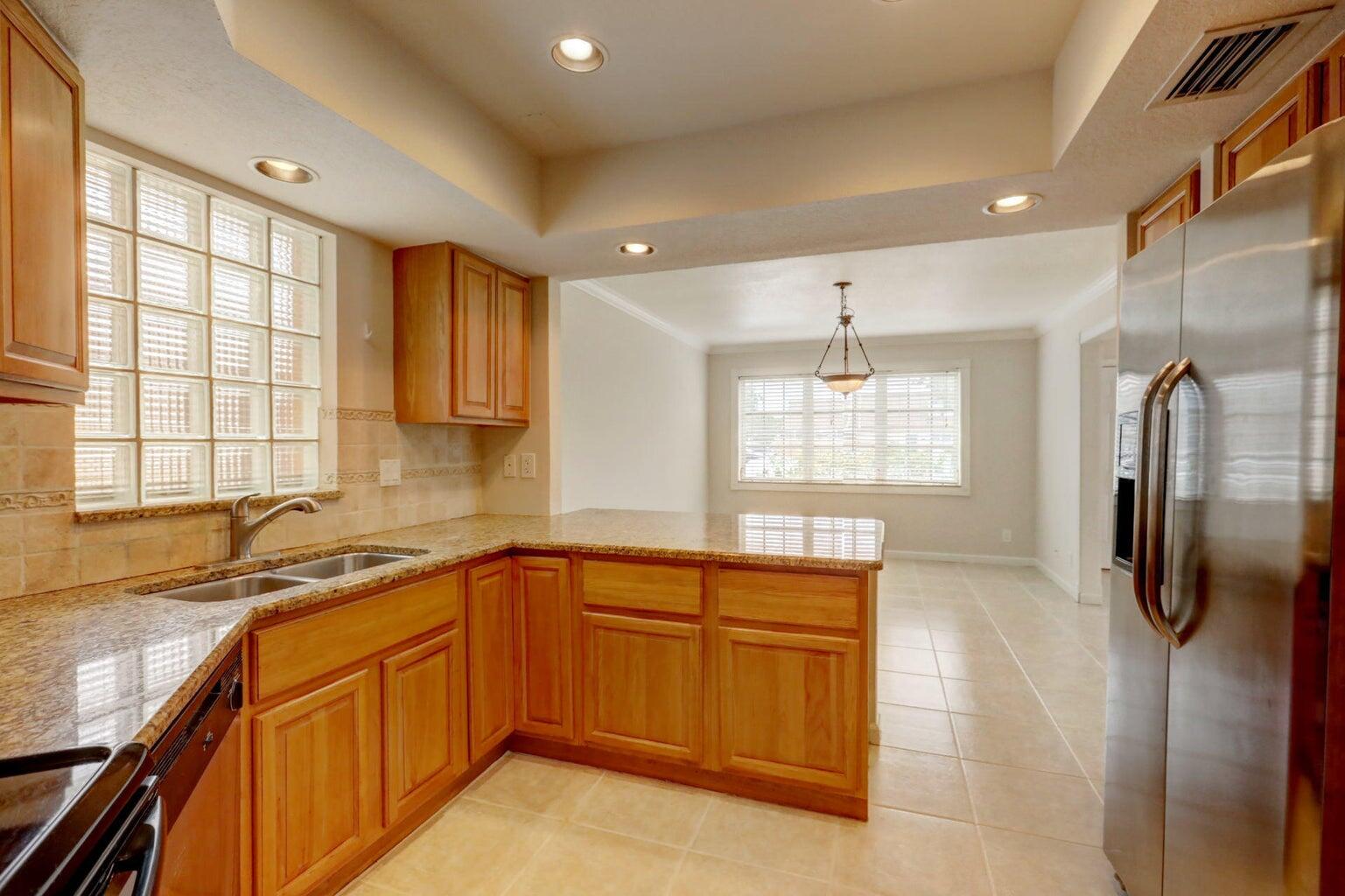 4356 Hazel Avenue, Unit C Palm Beach Gardens, FL 33410 - Photo 9 of 16 a kitchen with a sink a counter top space stainless steel appliances cabinets and a window